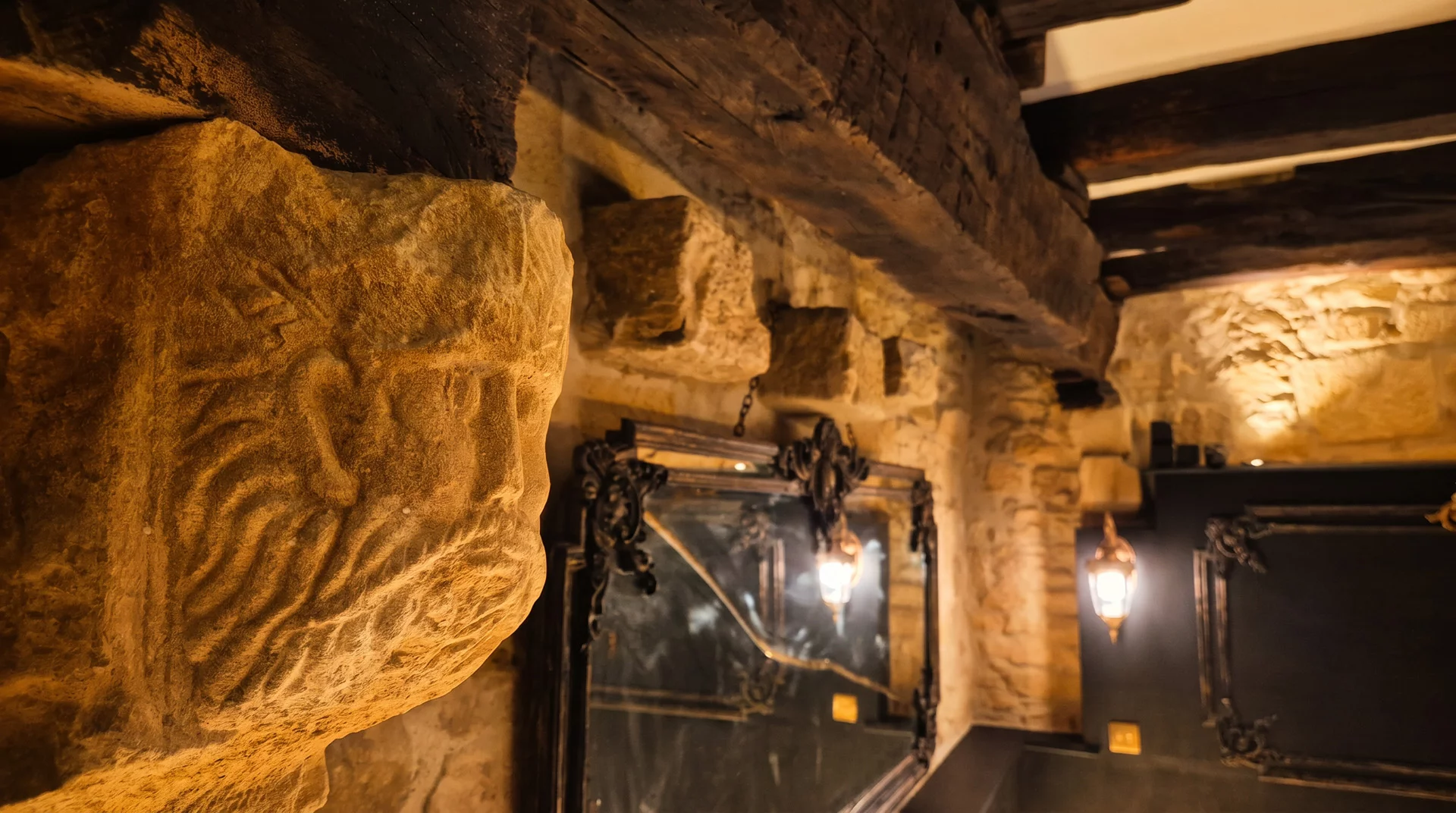 Miroirs baroques noirs et pierre dorée éclairée à la bougie dans la suite 1503 à Sarlat