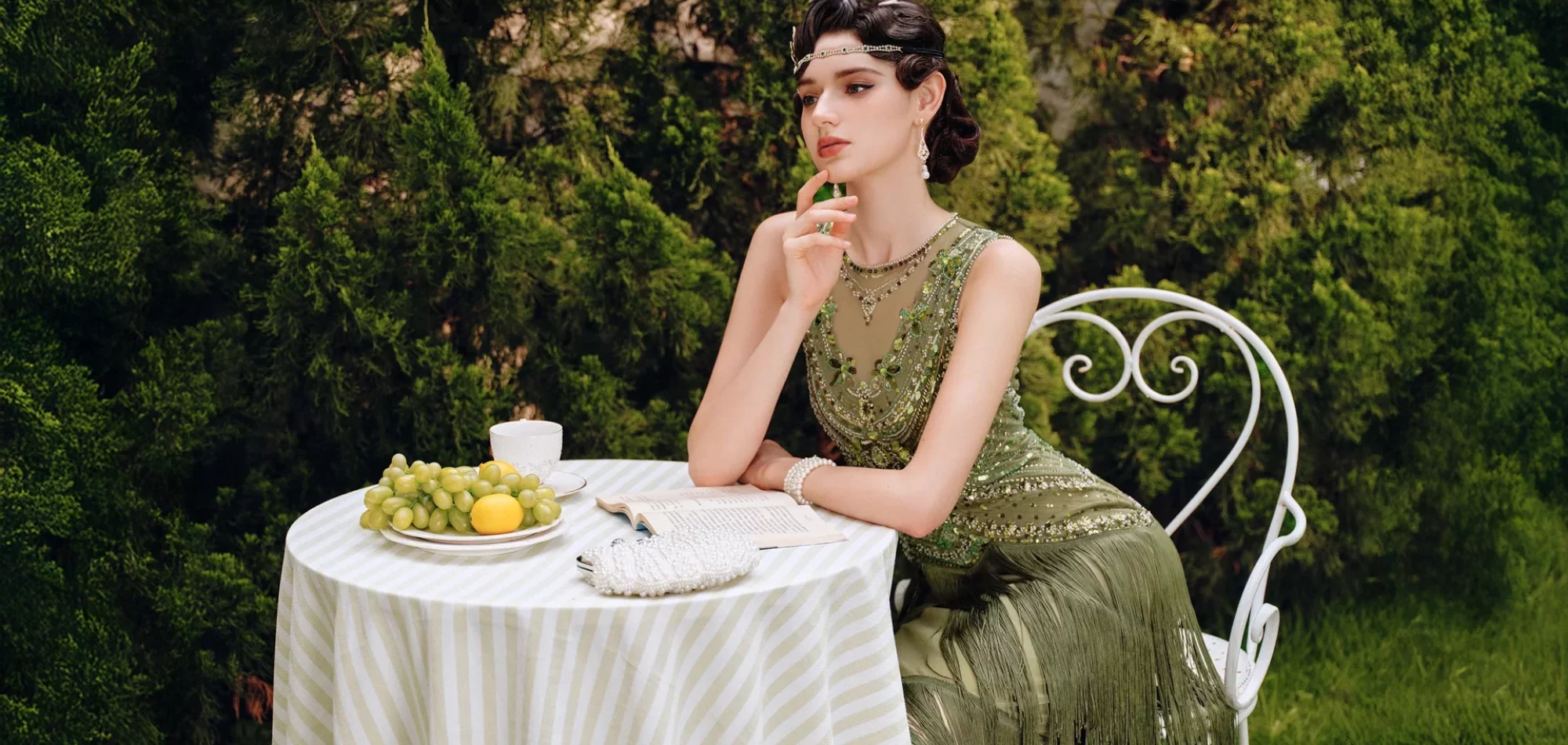 Visuel d’ambiance rétro du site Frenchy Lili : robe verte années 20 à une table de jardin