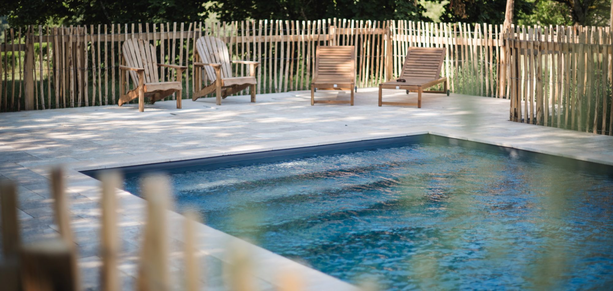 Piscine extérieure du Domaine de Malet à Vitrac, transats en bois et palissade, photo Emilie & Renaud