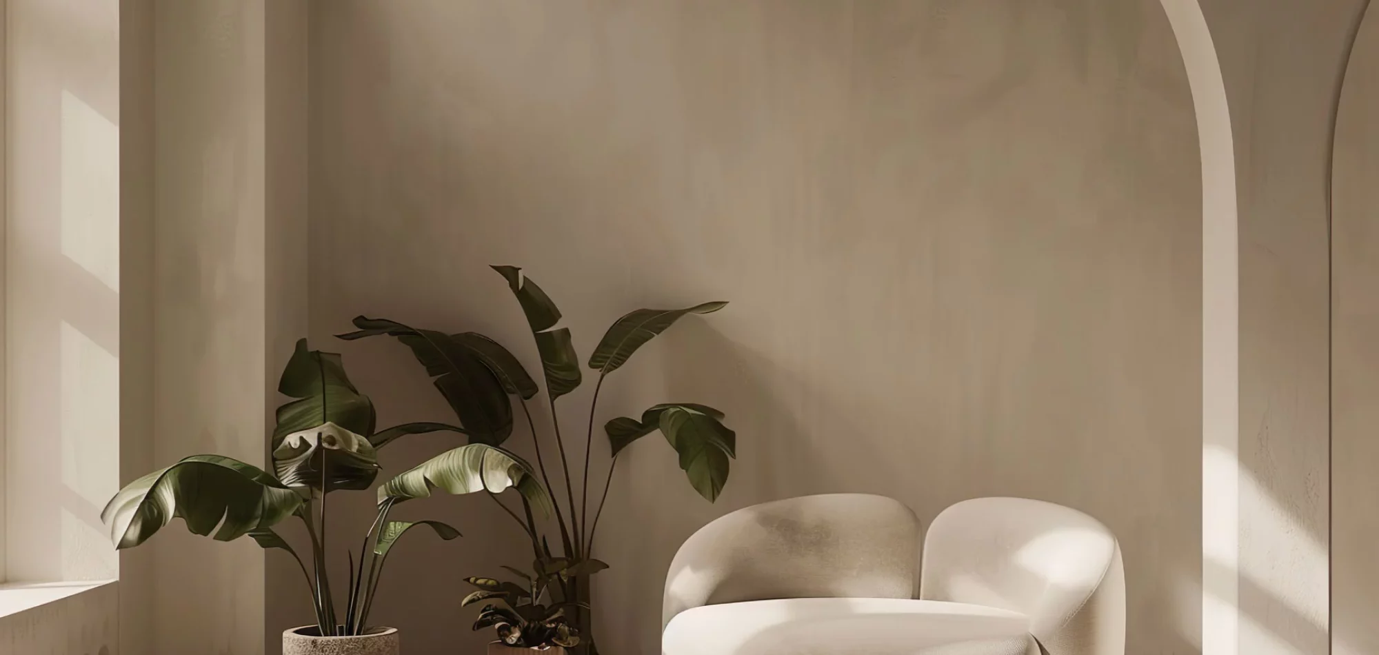 Fauteuil design et plantes dans un intérieur aux arches beiges, visuel d’ambiance de Home Expo Pro, mobilier d’exposition vendu par des pros